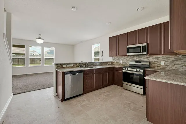 a kitchen with granite countertop stainless steel appliances and wooden cabinets