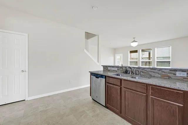 a kitchen with granite countertop a sink and cabinets