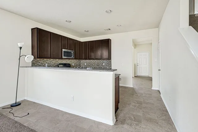 a kitchen with stainless steel appliances granite countertop a refrigerator and a sink