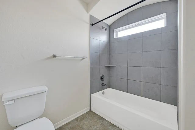a bathroom with a toilet and bathtub