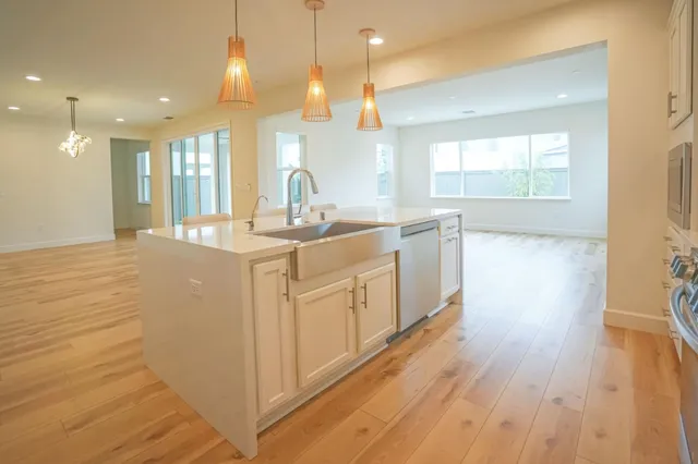 a kitchen with a sink a window stainless steel appliances and cabinets