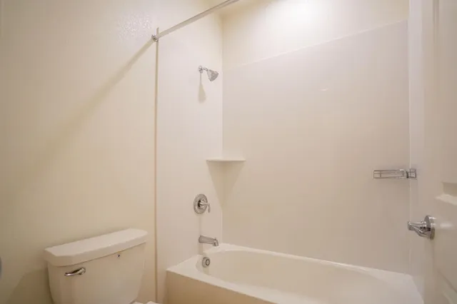 an empty room with closet and a bathroom