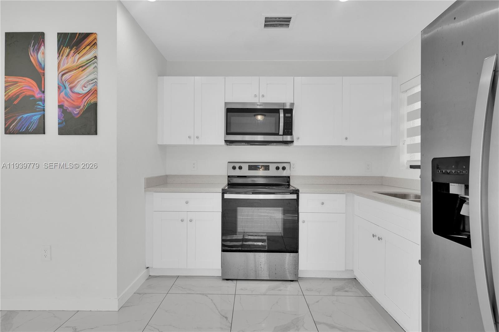 2490 Northwest 44th Street Miami, FL 33142 - Photo 37 of 57 a kitchen with stainless steel appliances a stove microwave and cabinets