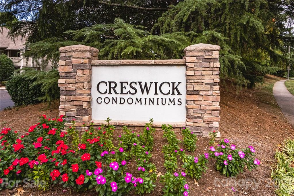 2539 Stockbridge Drive, Unit A Charlotte, NC 28210 - Photo 16 of 21 a sign board with flower plants and wooden fence
