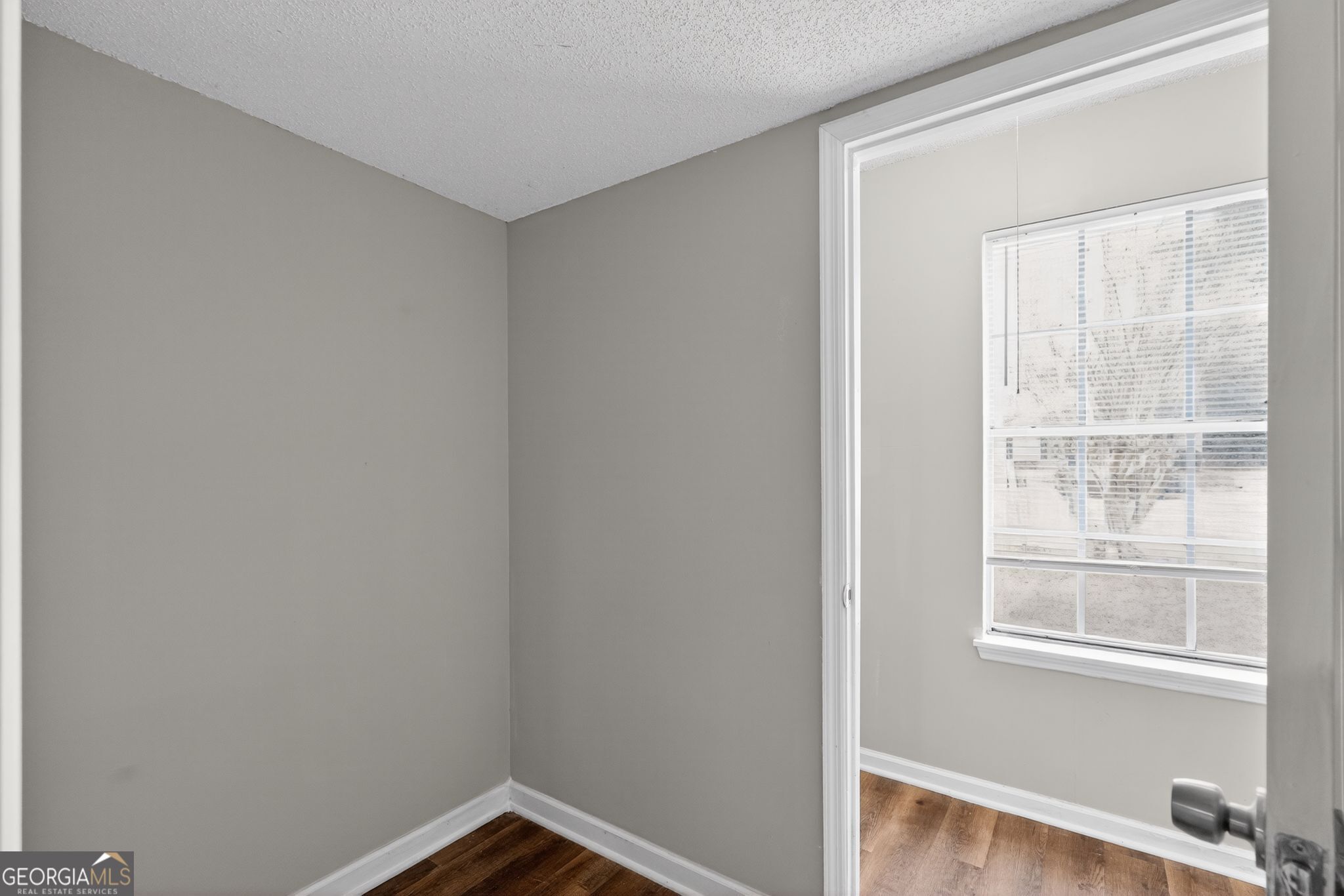 3263 River Mist Cove Decatur, GA 30034 - Photo 16 of 38 a view of an empty room with wooden floor and a window