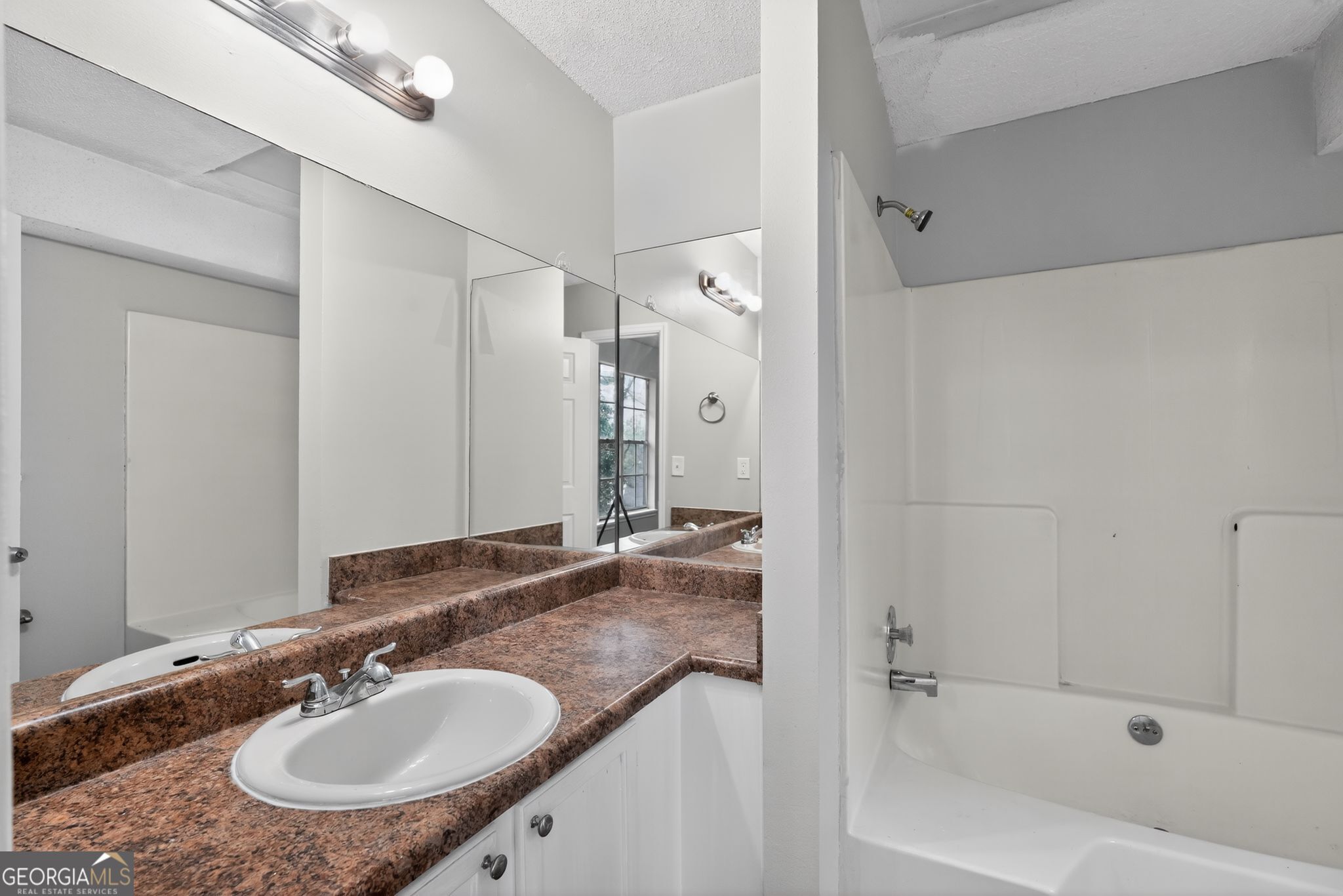 3263 River Mist Cove Decatur, GA 30034 - Photo 31 of 38 a bathroom with a granite countertop sink a mirror a bathtub and shower