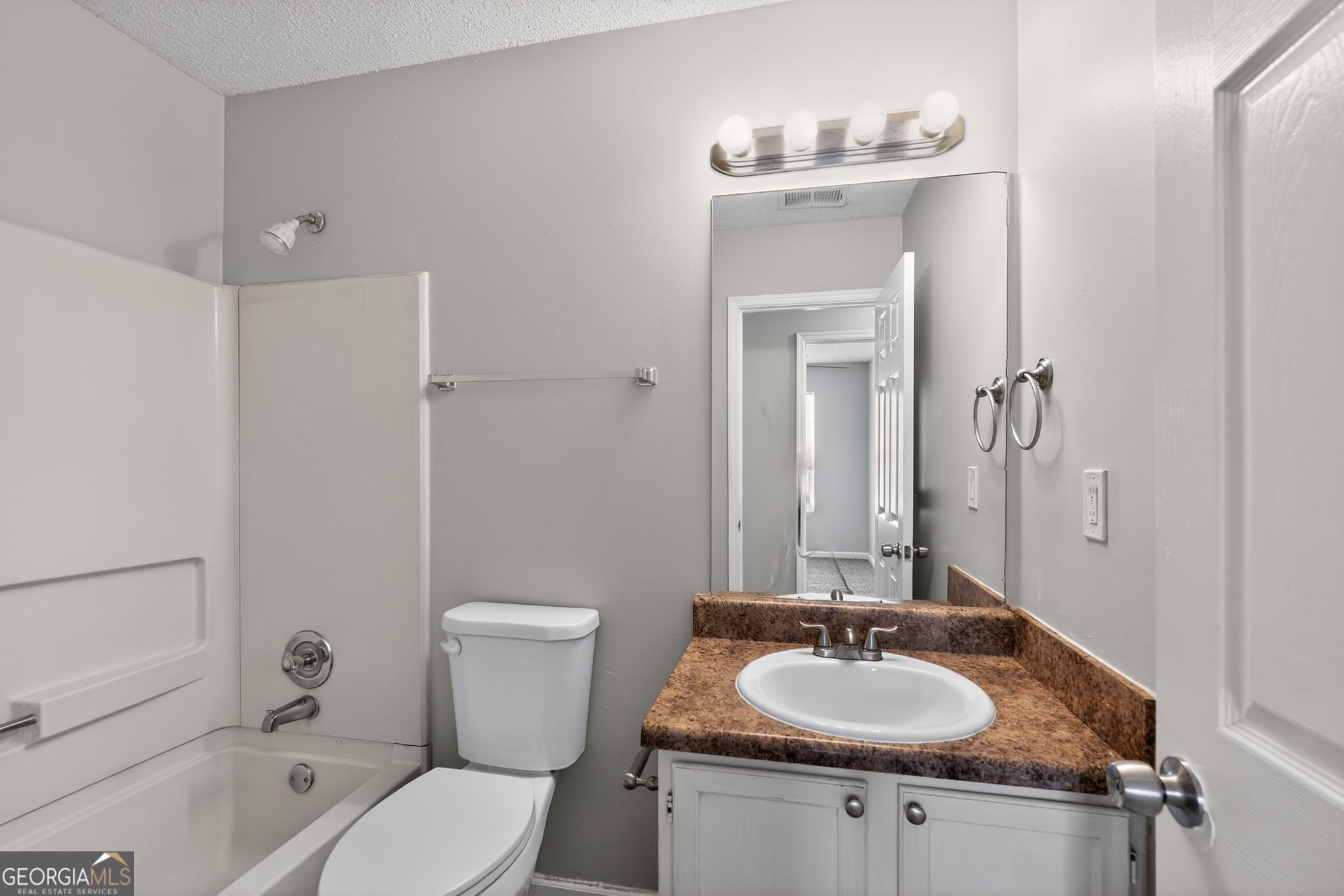 3263 River Mist Cove Decatur, GA 30034 - Photo 32 of 38 a bathroom with a granite countertop sink toilet a mirror and shower