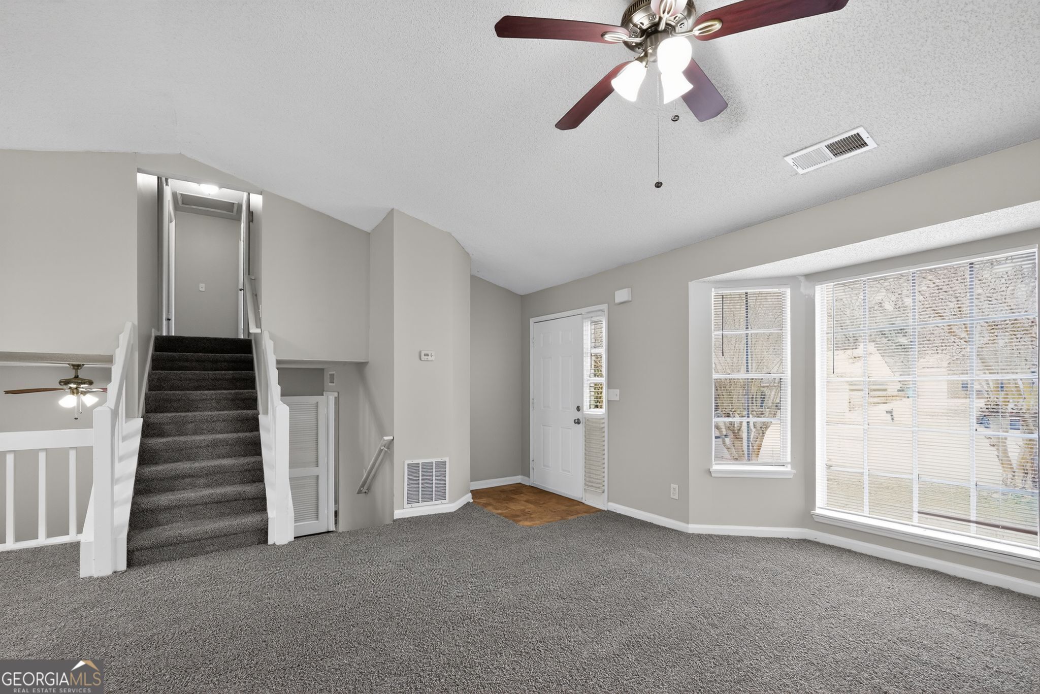 3263 River Mist Cove Decatur, GA 30034 - Photo 5 of 38 an empty room with staircase and ceiling fan