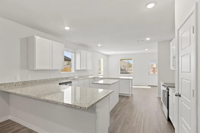 a kitchen with stainless steel appliances granite countertop a sink stove and cabinets