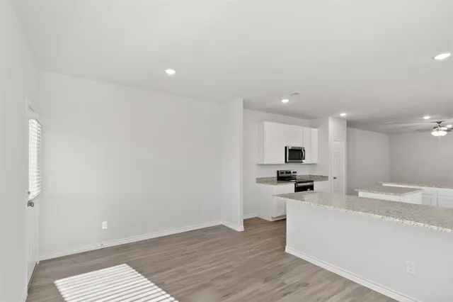 a view of kitchen with wooden floor and electronic appliances