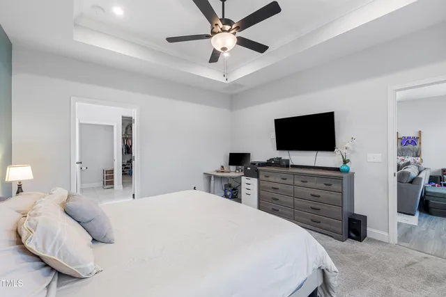 a bedroom with a large bed and ceiling fan