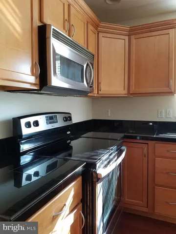 a kitchen with granite countertop a stove and a microwave