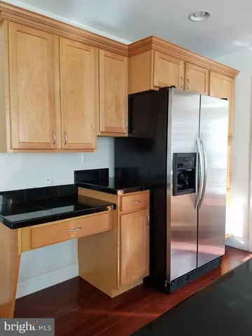 a kitchen with granite countertop a refrigerator a stove and a sink