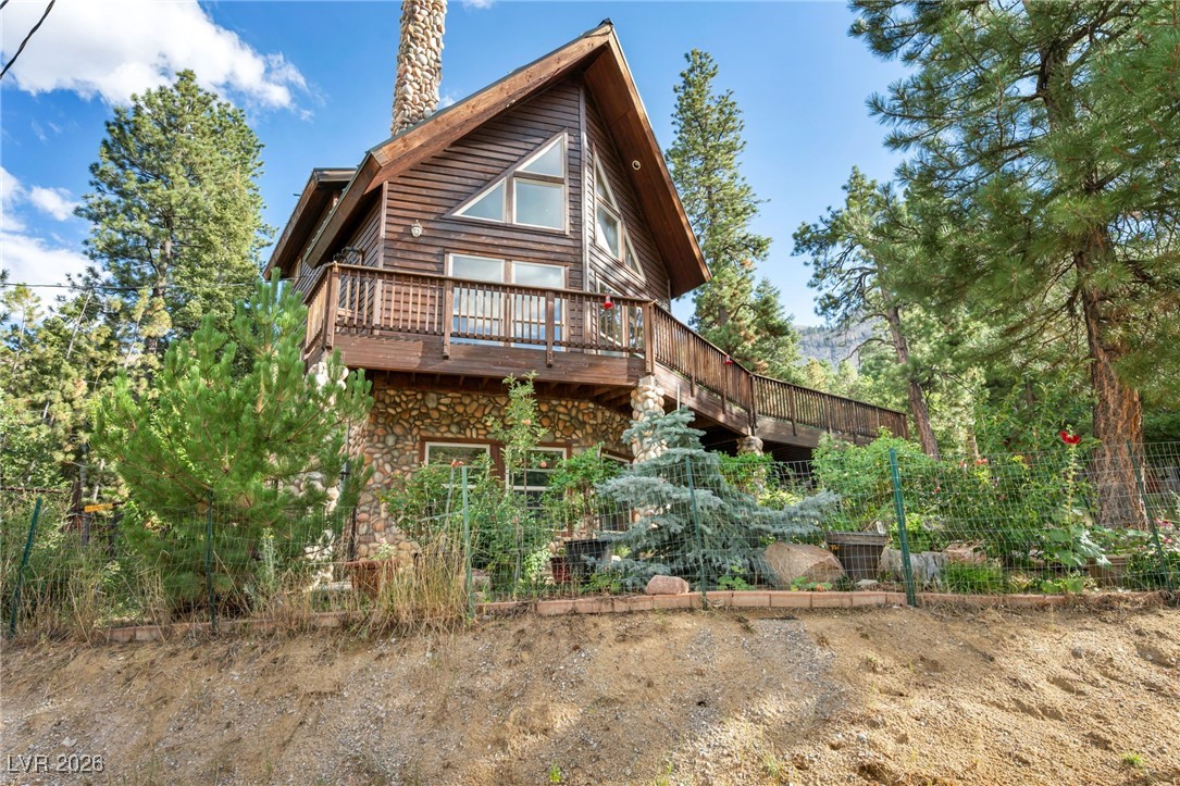 4137 Matterhorn Way Las Vegas, NV 89124 - Photo 3 of 75 Back of house with a wooden deck, stone siding, and a chimney