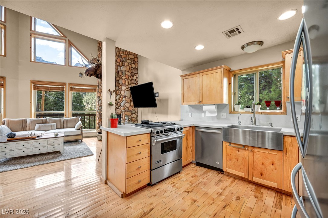 4137 Matterhorn Way Las Vegas, NV 89124 - Photo 73 of 75 Kitchen featuring open floor plan, light brown cabinetry, stainless steel appliances, light wood-style floors, and recessed lighting