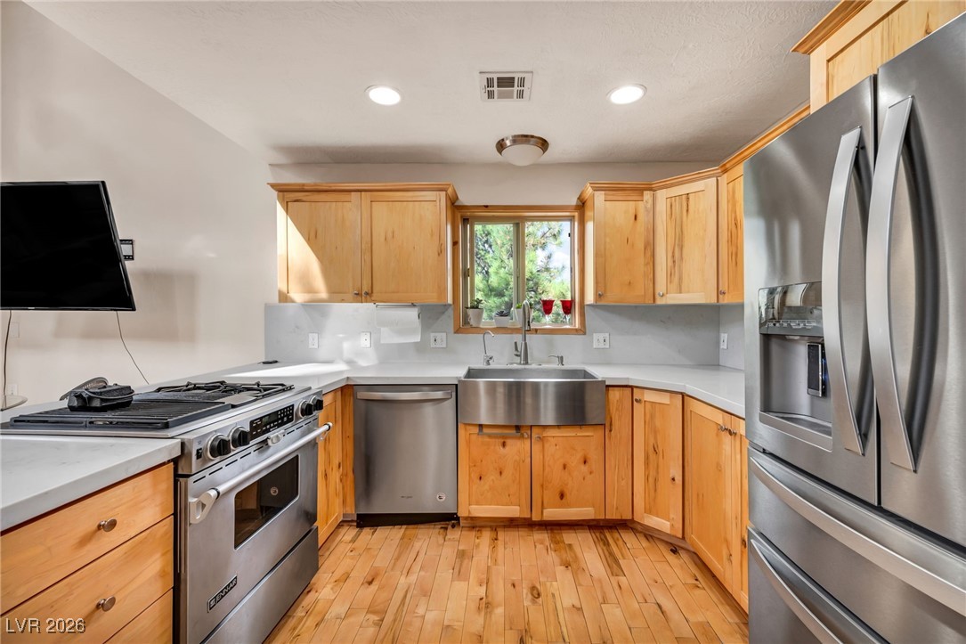 4137 Matterhorn Way Las Vegas, NV 89124 - Photo 39 of 75 Kitchen with stainless steel appliances, light wood-style flooring, backsplash, light brown cabinets, and recessed lighting