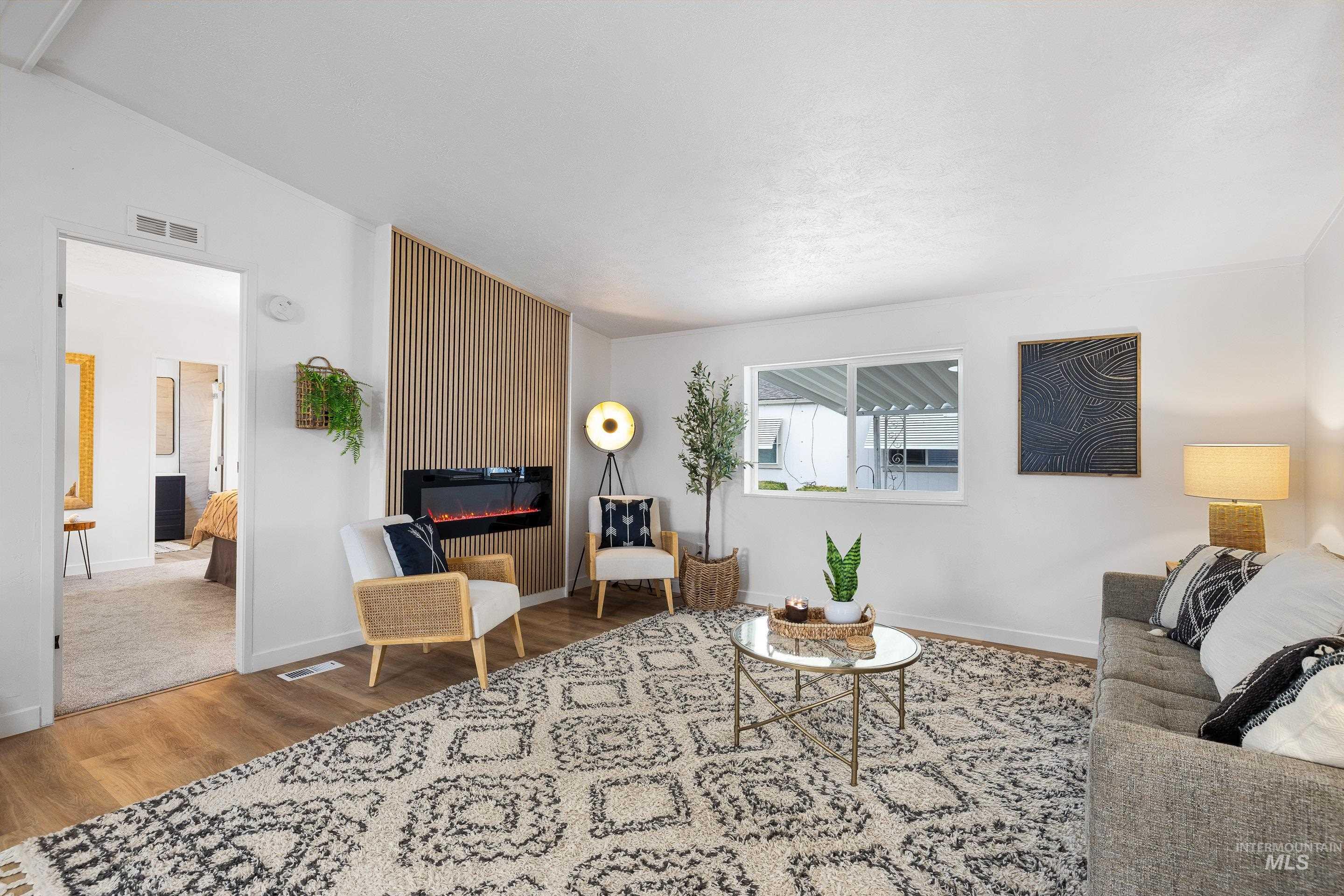 10014 Dewitt Lane Boise, ID 83704 - Photo 11 of 50 Living area with wood finished floors, a fireplace, and lofted ceiling