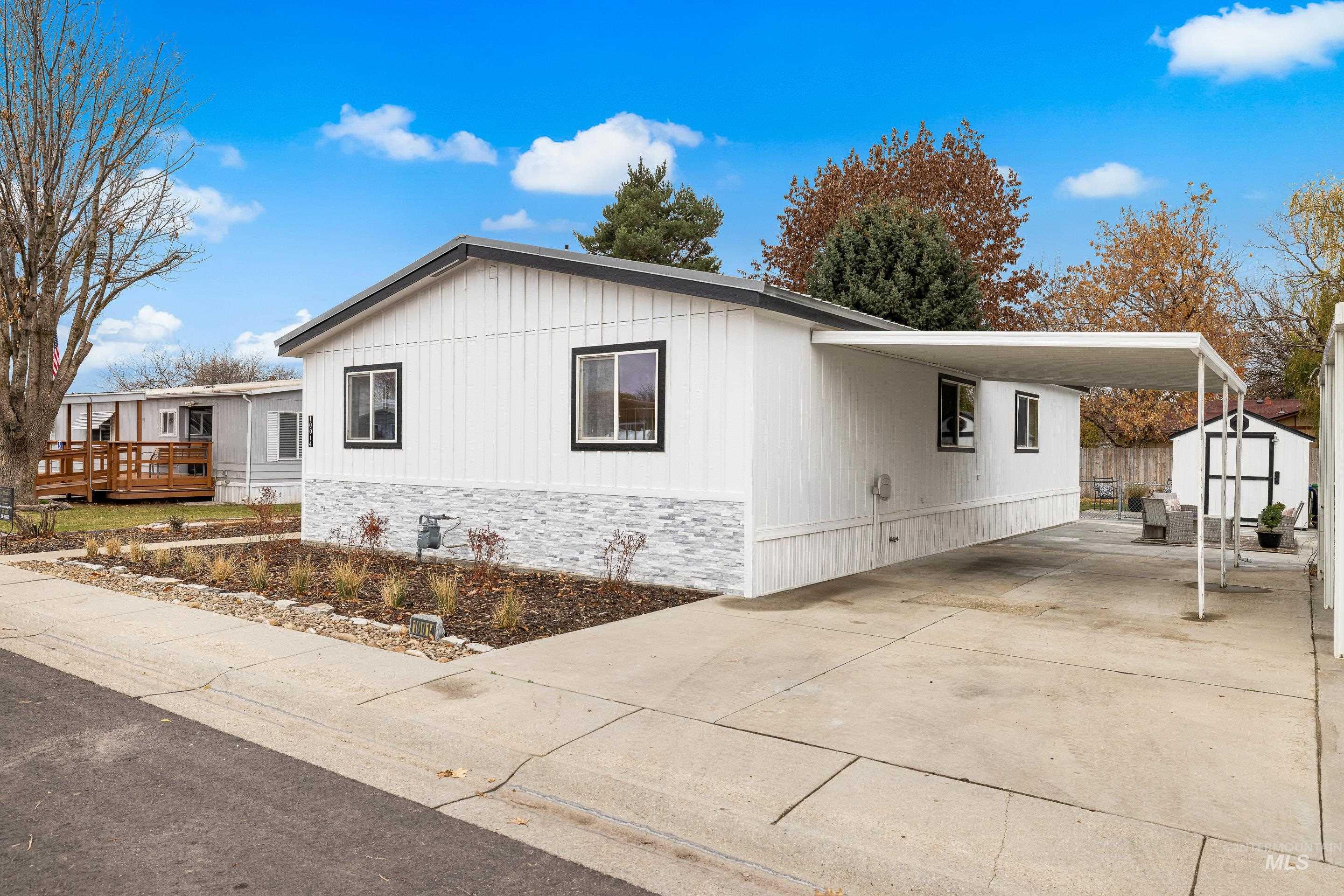 10014 Dewitt Lane Boise, ID 83704 - Photo 2 of 50 View of side of home with a storage unit, driveway, an attached carport, and a deck