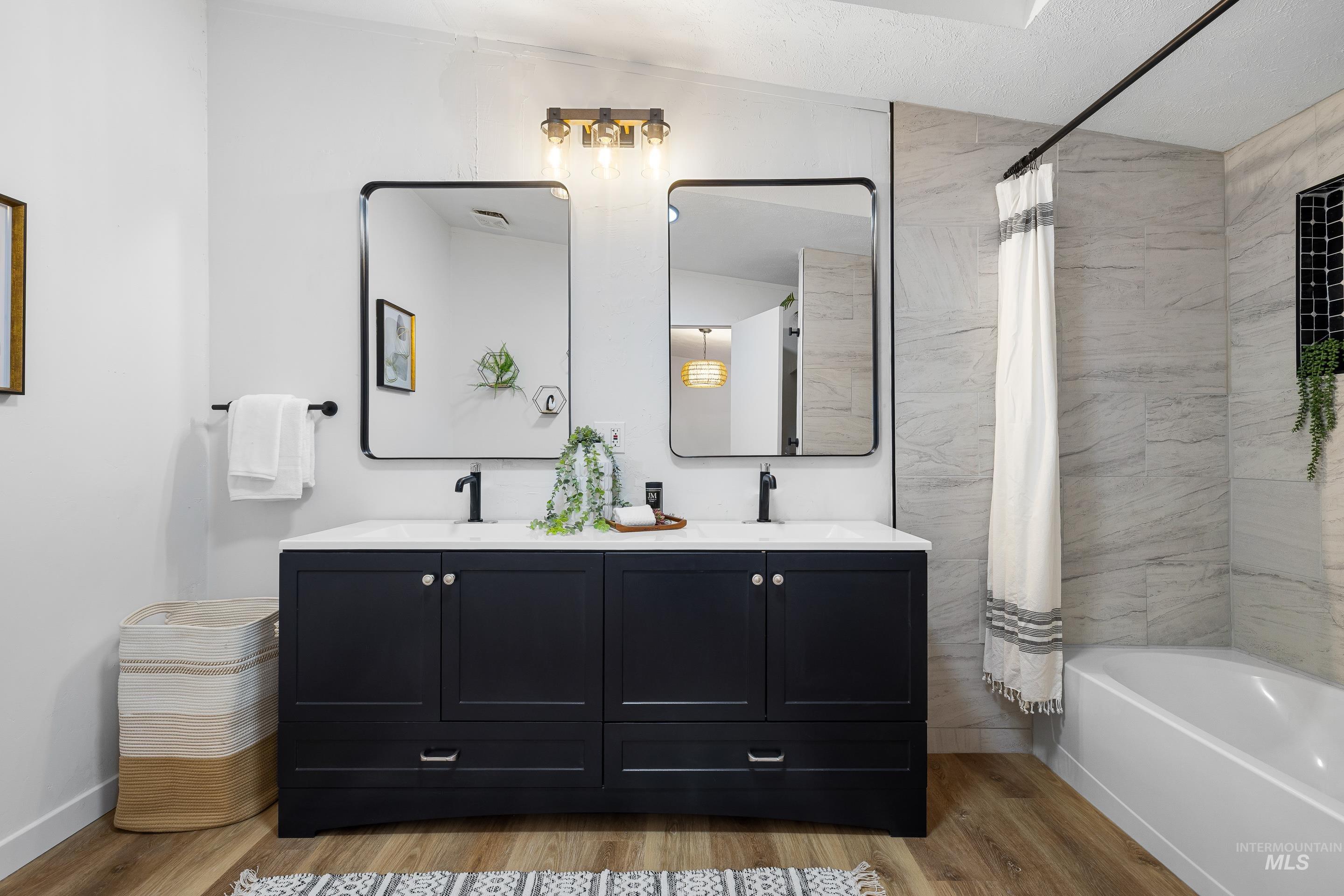 10014 Dewitt Lane Boise, ID 83704 - Photo 33 of 50 Full bathroom with double vanity, light wood-type flooring, and shower / tub combo with curtain