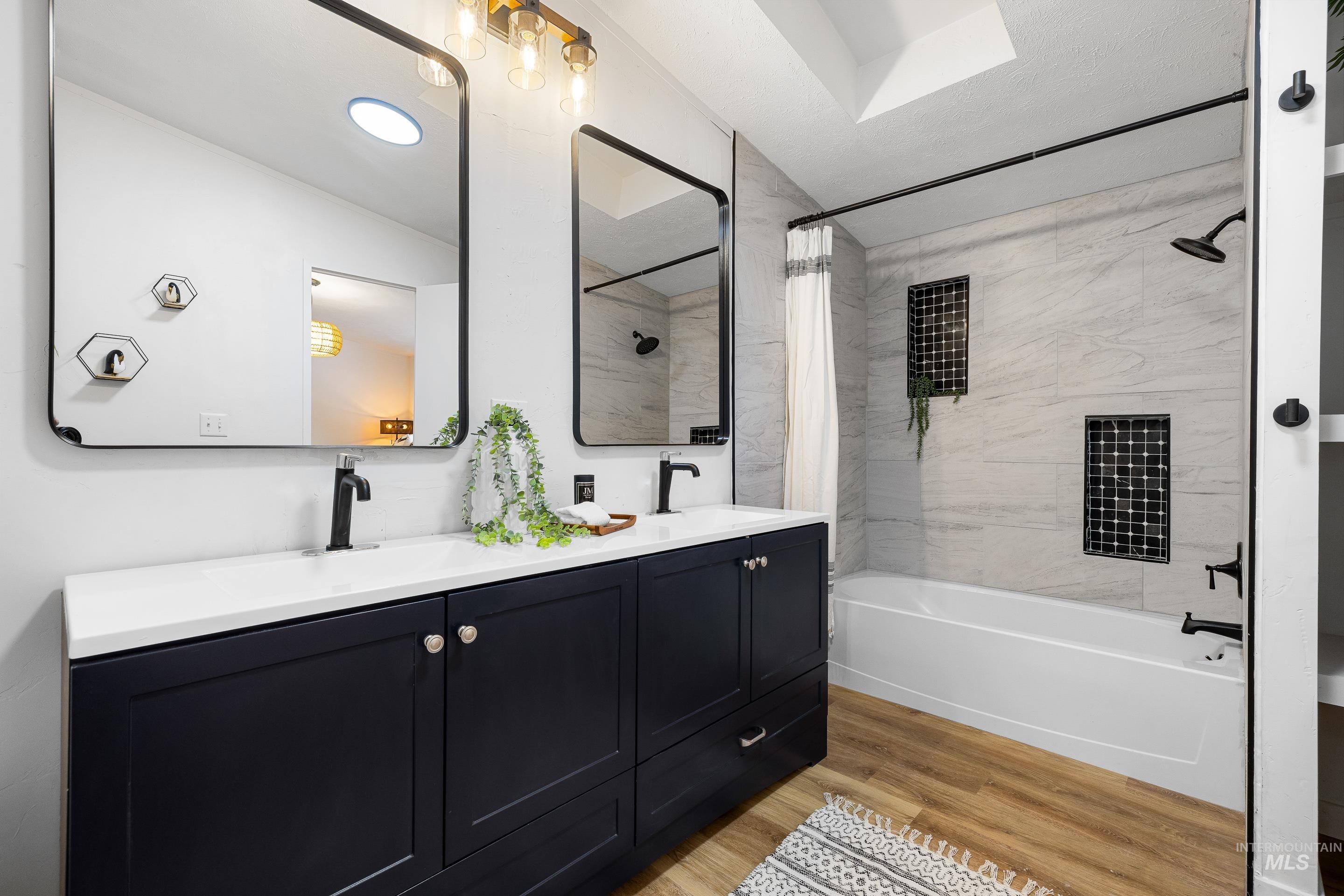 10014 Dewitt Lane Boise, ID 83704 - Photo 34 of 50 Full bath featuring shower / bathtub combination with curtain, light wood-style flooring, and double vanity