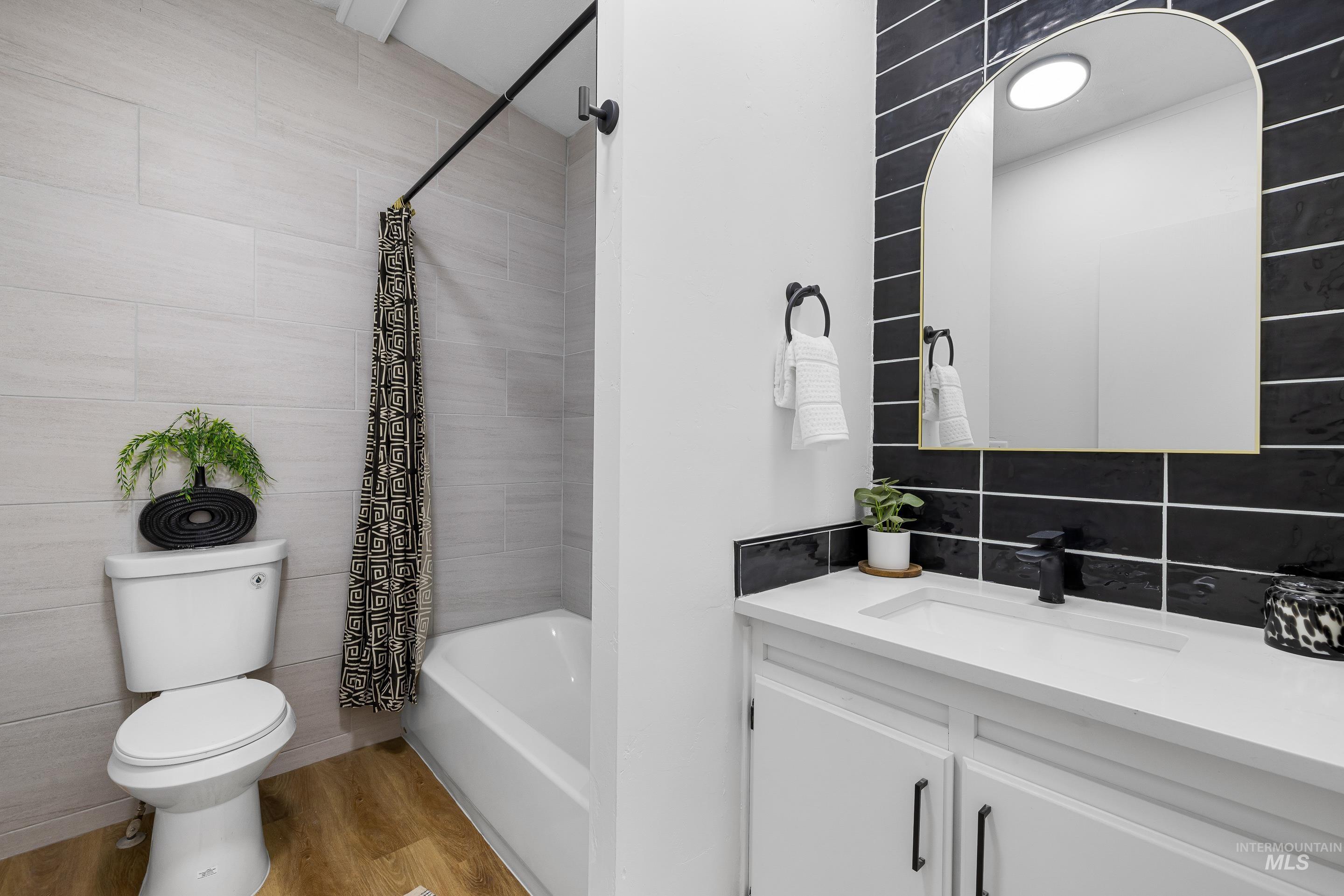 10014 Dewitt Lane Boise, ID 83704 - Photo 41 of 50 Bathroom featuring light wood-type flooring, vanity, shower / bath combination with curtain, and backsplash