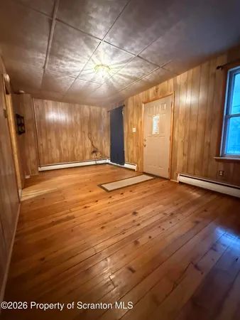 a view of an empty room with wooden floor