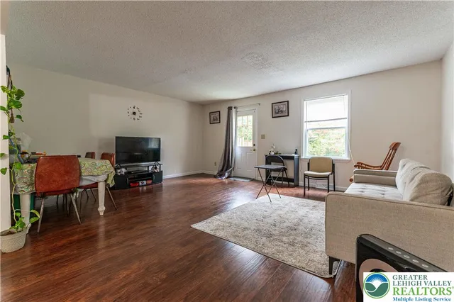 a living room with furniture a window and a flat screen tv