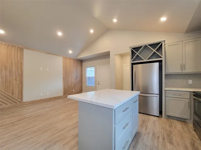 a kitchen with stainless steel appliances a refrigerator and wooden floor