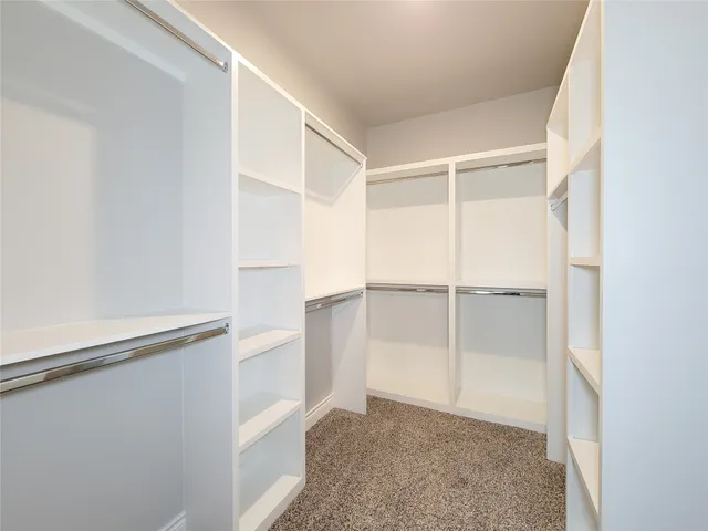 an empty room with closet and a chandelier fan