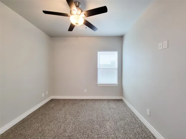 an empty room with chandelier fan