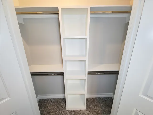 a view of walk in closet with empty racks