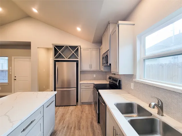 a kitchen with a refrigerator sink and cabinets