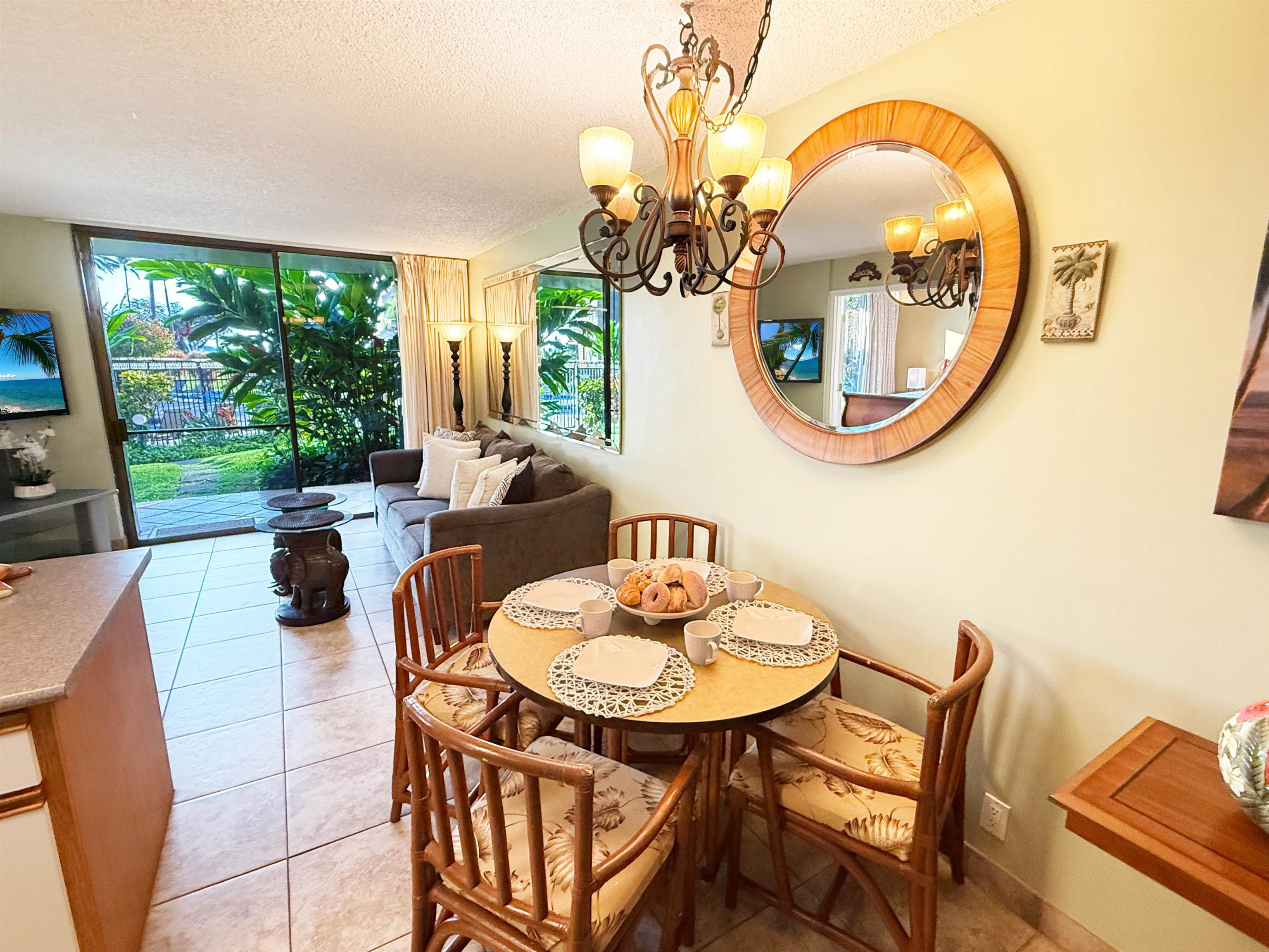 938 South Kihei Road, Unit 109 Kihei, HI 96753 - Photo 11 of 30 a dining room with wooden floor a glass table and chairs