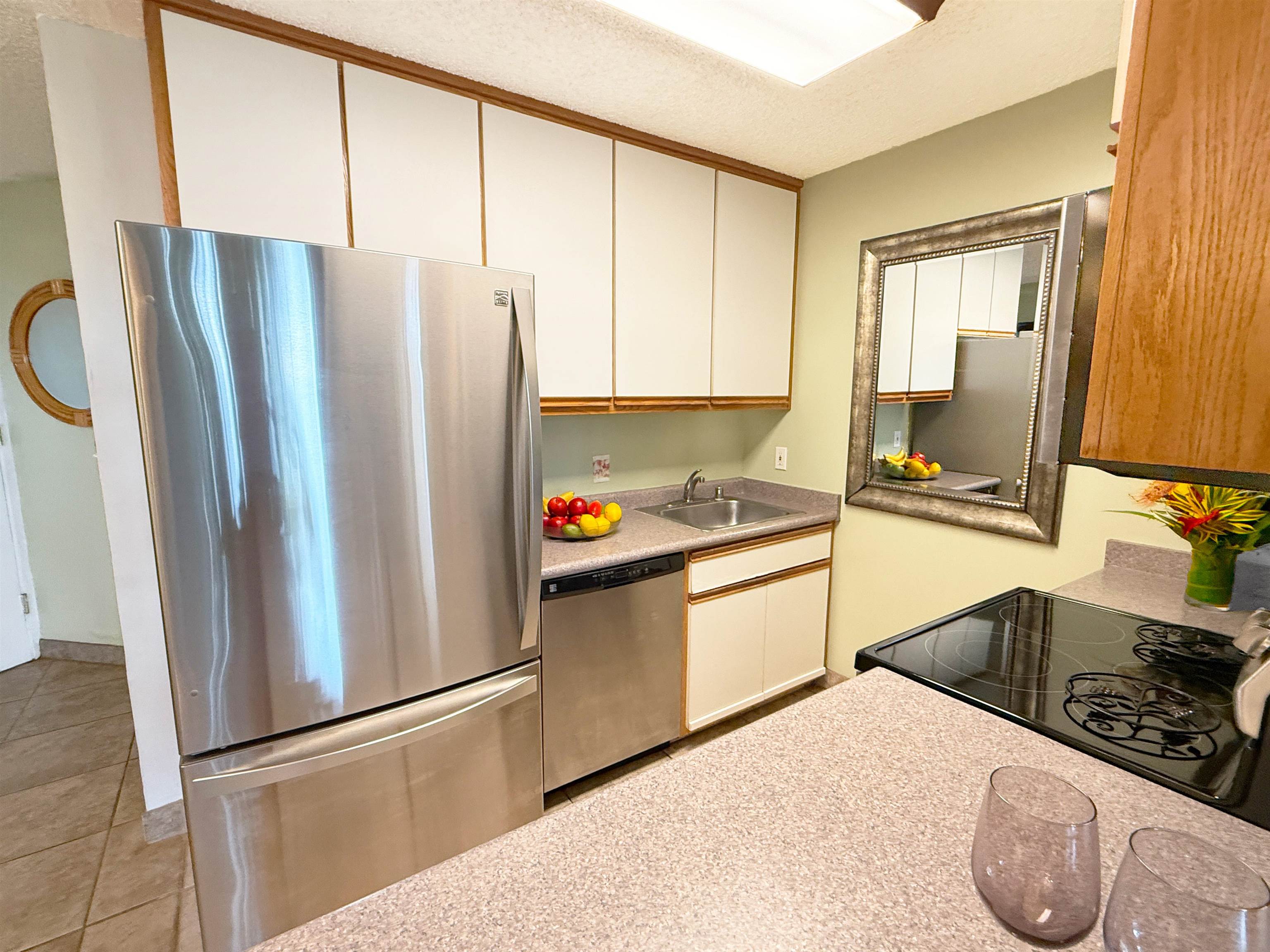 938 South Kihei Road, Unit 109 Kihei, HI 96753 - Photo 13 of 30 a kitchen with stainless steel appliances a refrigerator sink and cabinets