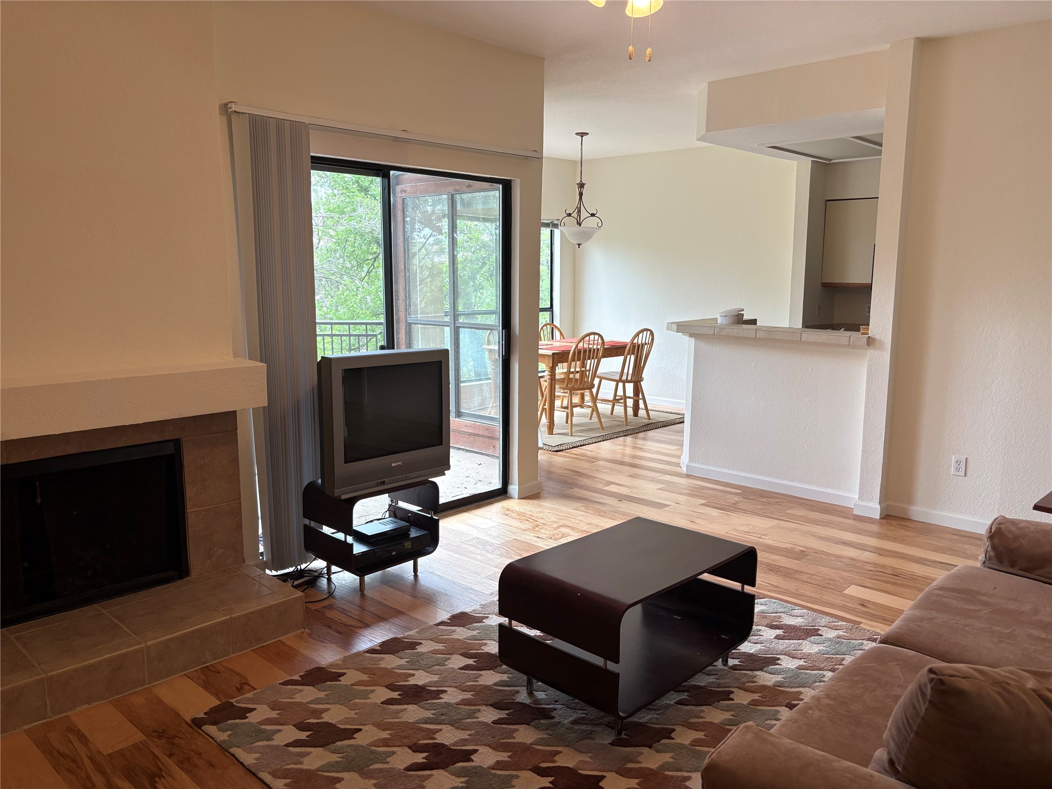 Living room featuring light wood-style floors and a fireplace with raised hearth