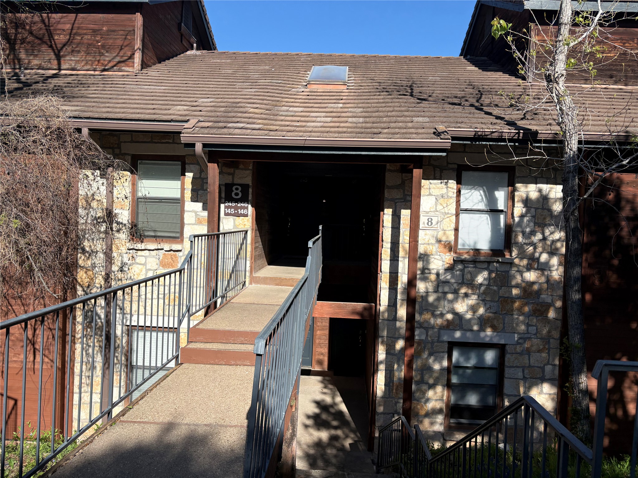 4711 Spicewood Springs Road, Unit 8146 Austin, TX 78759 - Photo 4 of 14 View of exterior entry with stone siding and covered porch