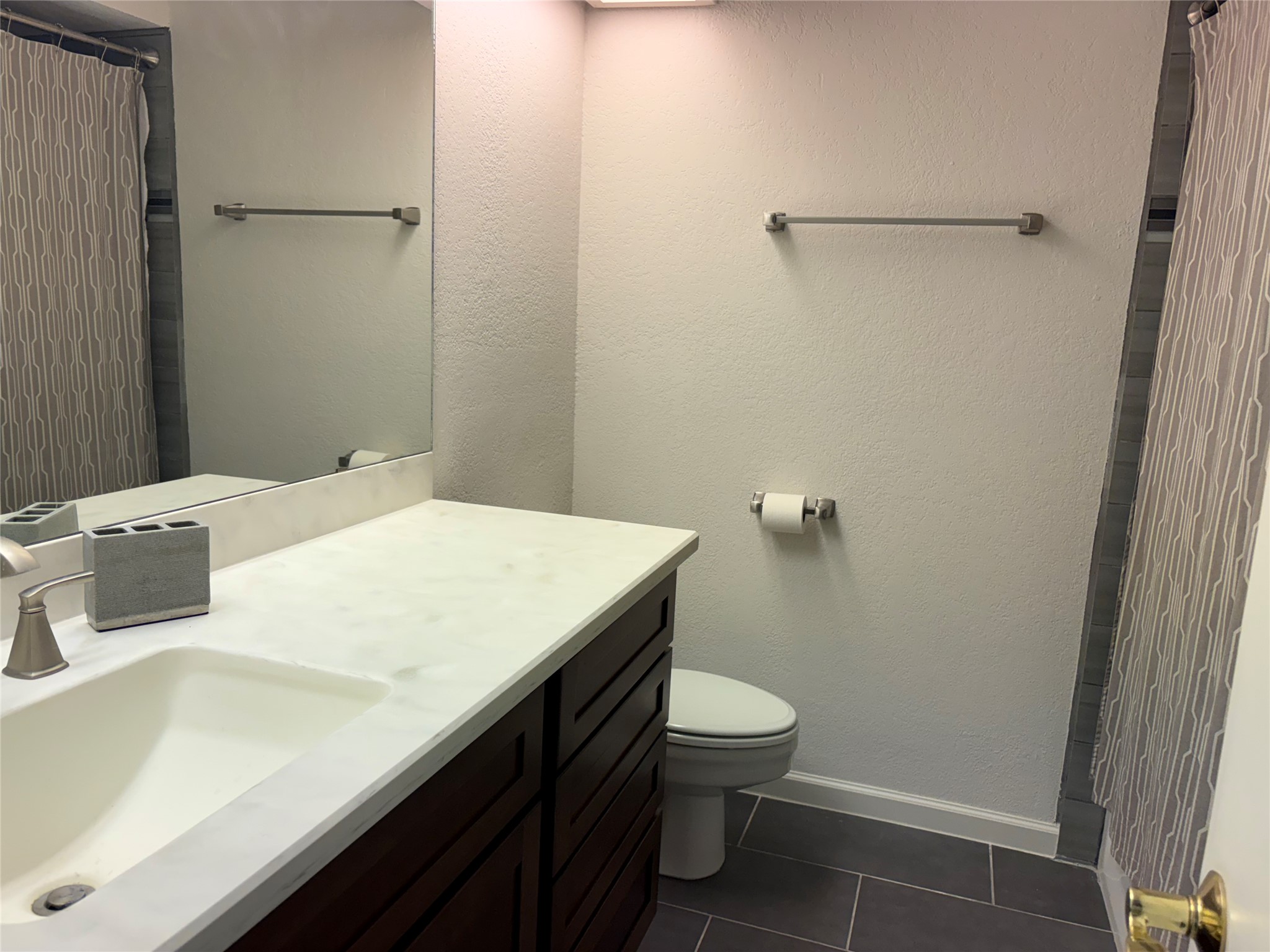 4711 Spicewood Springs Road, Unit 8146 Austin, TX 78759 - Photo 10 of 14 Bathroom with a shower with curtain, vanity, dark tile patterned flooring, and a textured wall