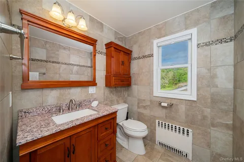 a bathroom with a granite countertop sink and a mirror