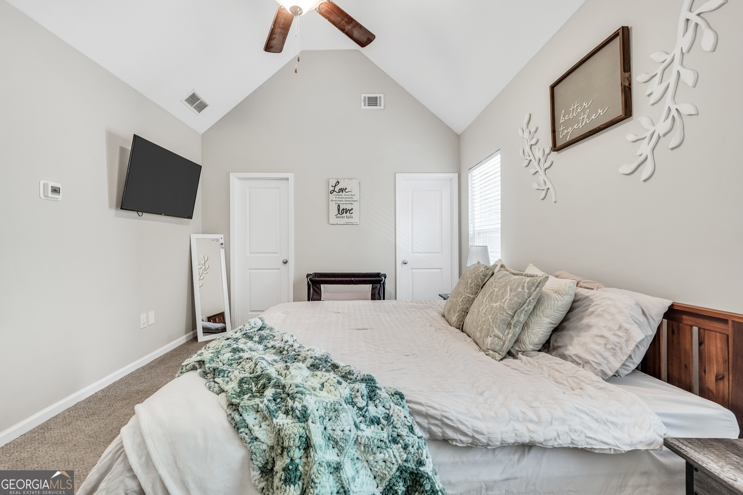 117 Charleston Lane Milner, GA 30257 - Photo 16 of 34 a bedroom with a bed a flat screen tv and a chandelier