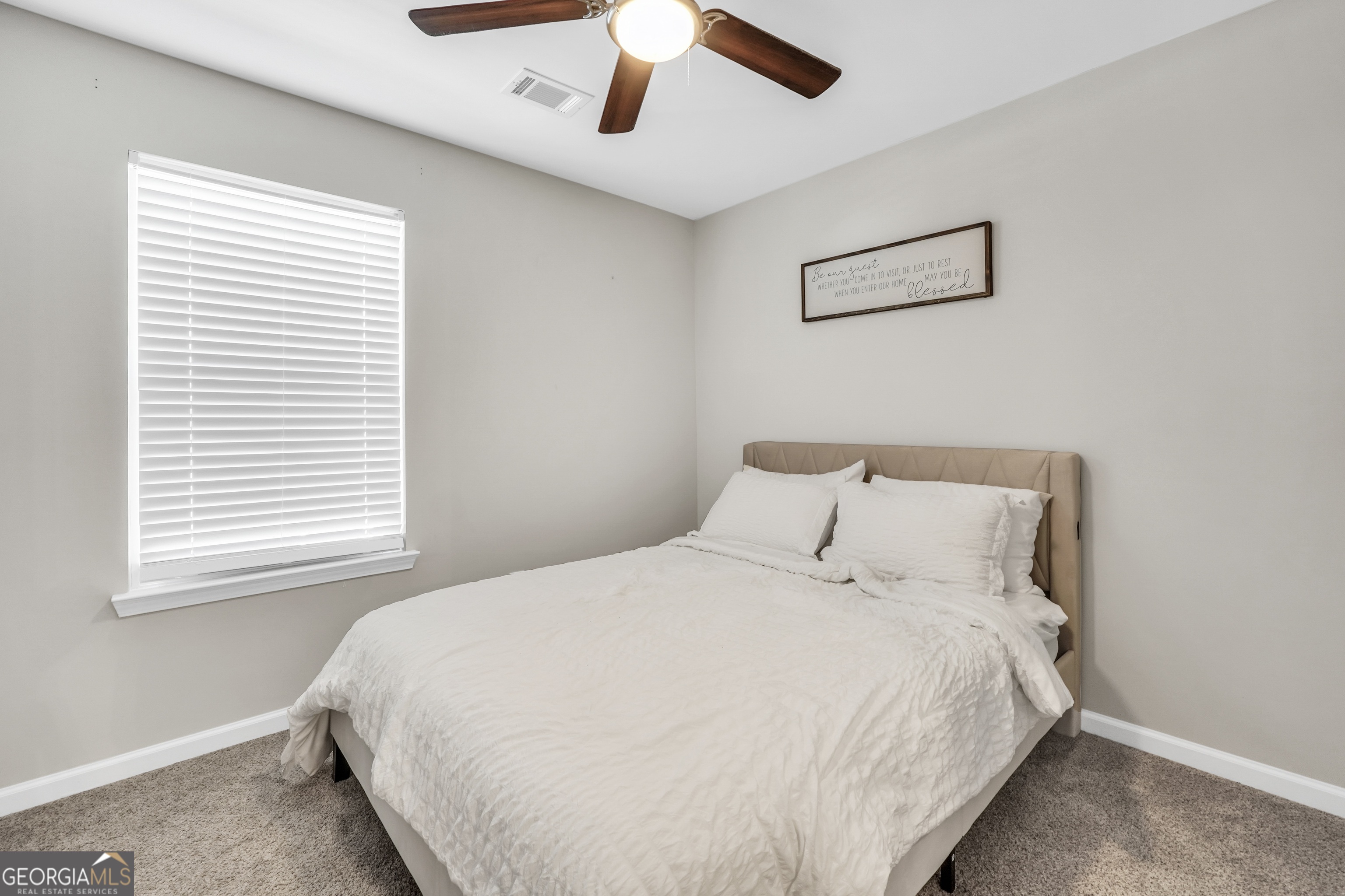 117 Charleston Lane Milner, GA 30257 - Photo 21 of 34 a large bed sitting in a bedroom next to a window
