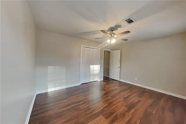 a view of an empty room with wooden floor