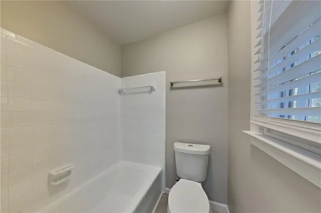 a white toilet sitting next to a bath tub