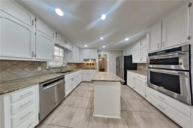 a large kitchen with cabinets stainless steel appliances and a counter space