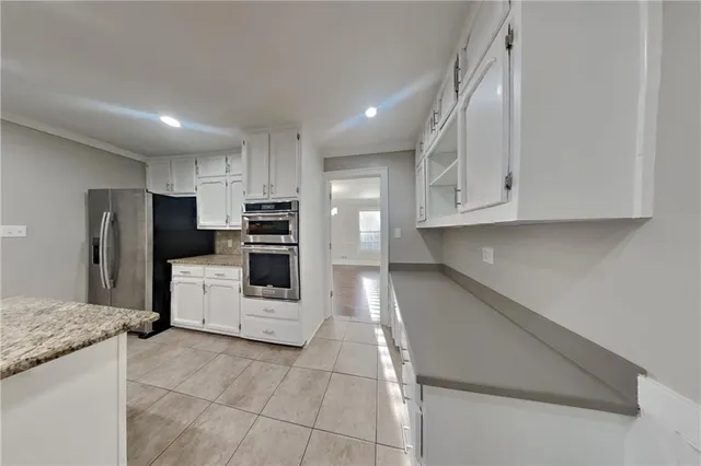 a kitchen with stainless steel appliances granite countertop a refrigerator and a stove