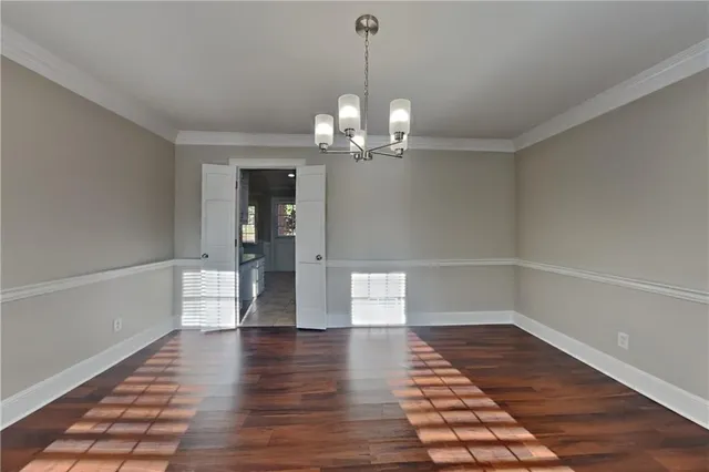 a view of a room with wooden floor and white walls