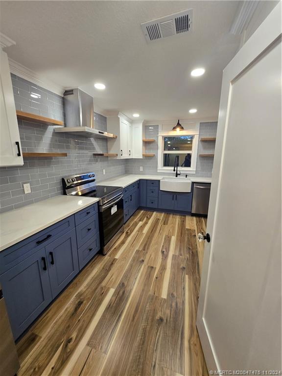 420 Southwest 7th Street Stuart, FL 34994 - Photo 8 of 17 a kitchen with wooden floors and stainless steel appliances