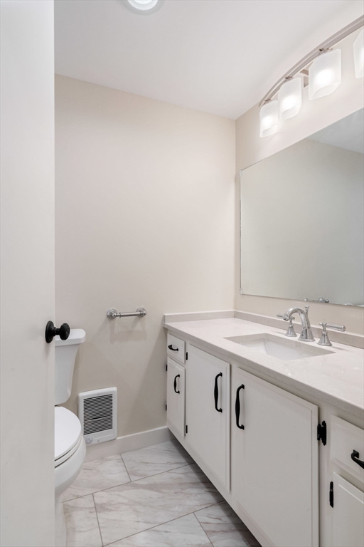 130 Fulton Street, Unit 16 Boston, MA 02109 - Photo 12 of 22 a bathroom with a granite countertop sink and a toilet