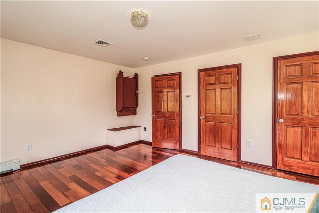 230 McFarlane Road Colonia, NJ 07067 - Photo 25 of 43 a bedroom with a bed and wooden floor
