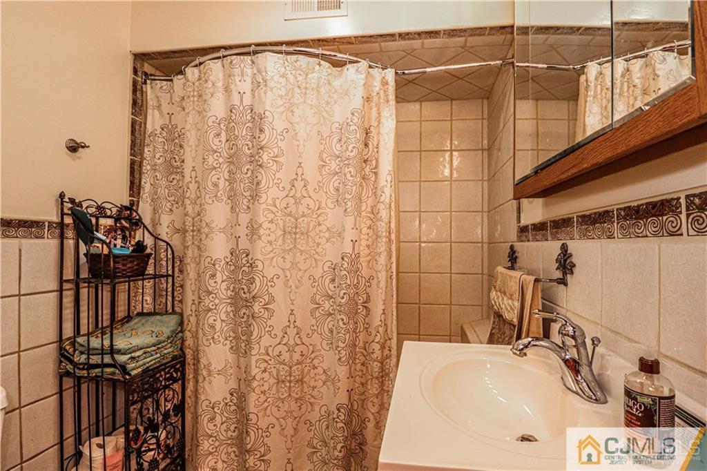230 McFarlane Road Colonia, NJ 07067 - Photo 36 of 43 a bathroom with a sink and shower curtain