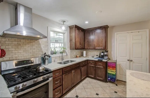 a kitchen that has a sink cabinets counter space and a window